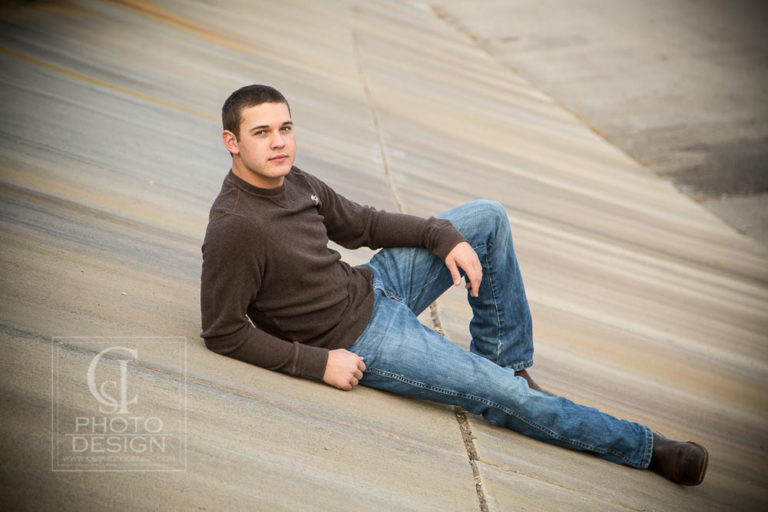Senior boy reclining on a concrete canal bank