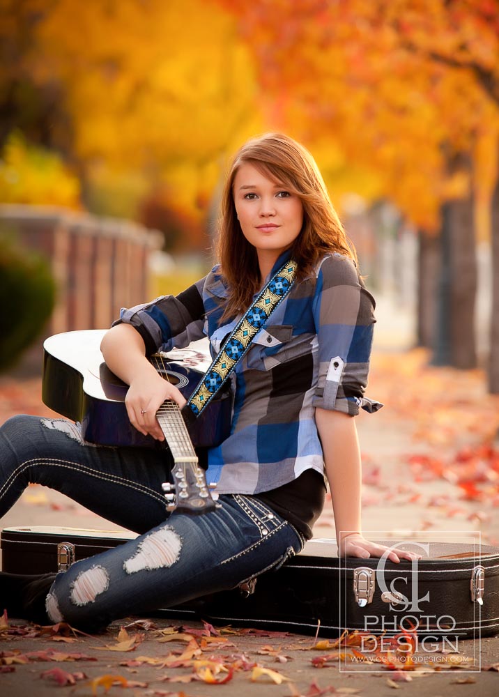 Senior girl with acoustic guitar with fall leaves in the background
