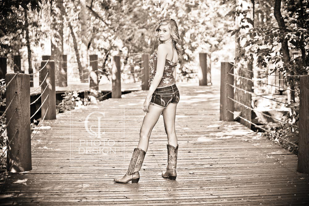 Senior girl on a wood walkway in cowboy boots