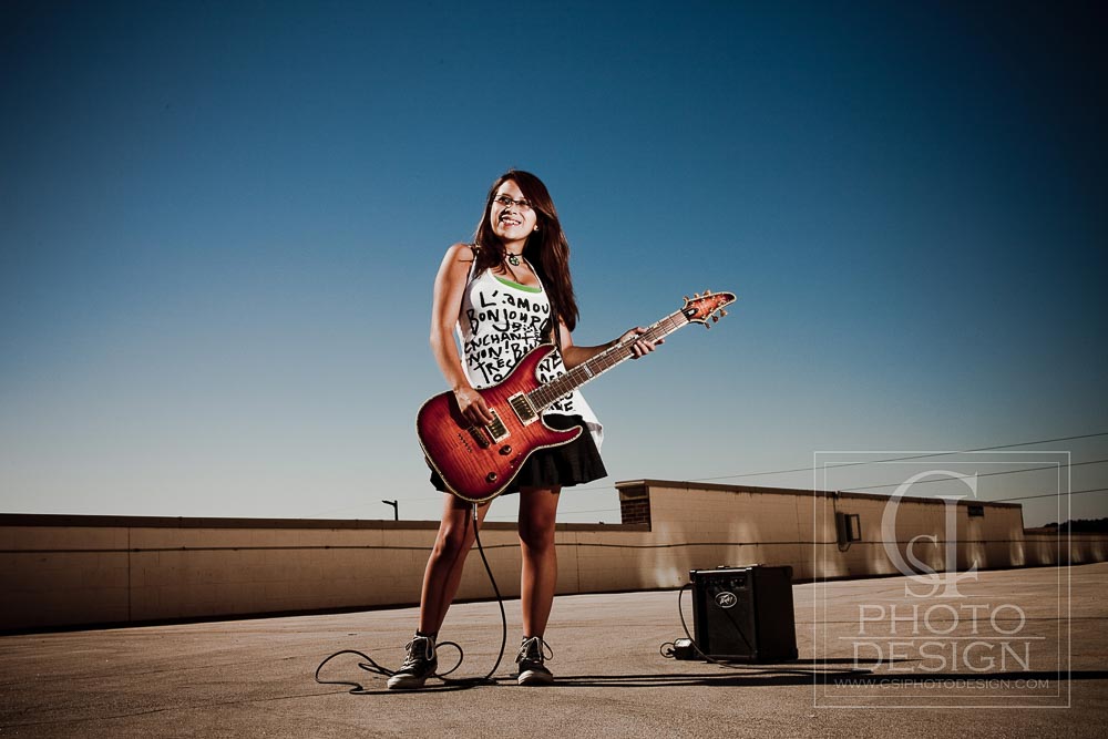 Senior girl with electric guitar on a parking garage