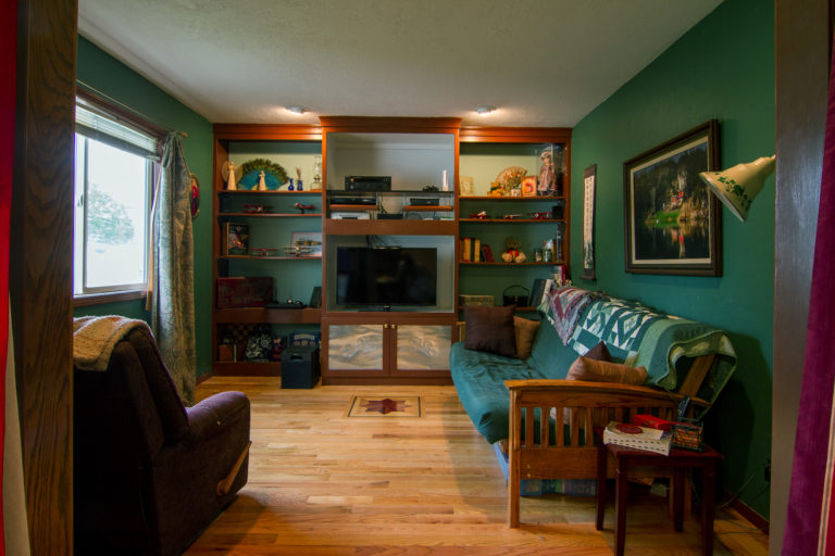 family with green walls and hardwood floor